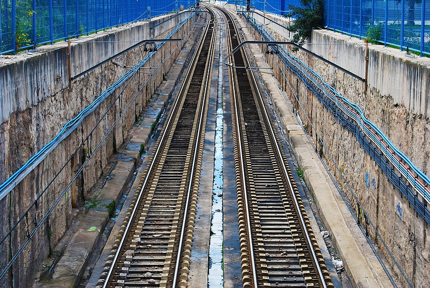 Symmetrical view of empty train tracks in concrete trench