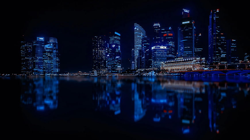 Illuminated City Skyline Reflected in Water at Night