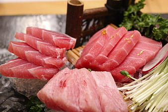 Fresh raw tuna sashimi slices on ice with garnish