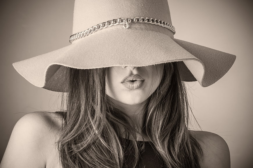 Fashionable woman wearing wide-brimmed hat with chain detail