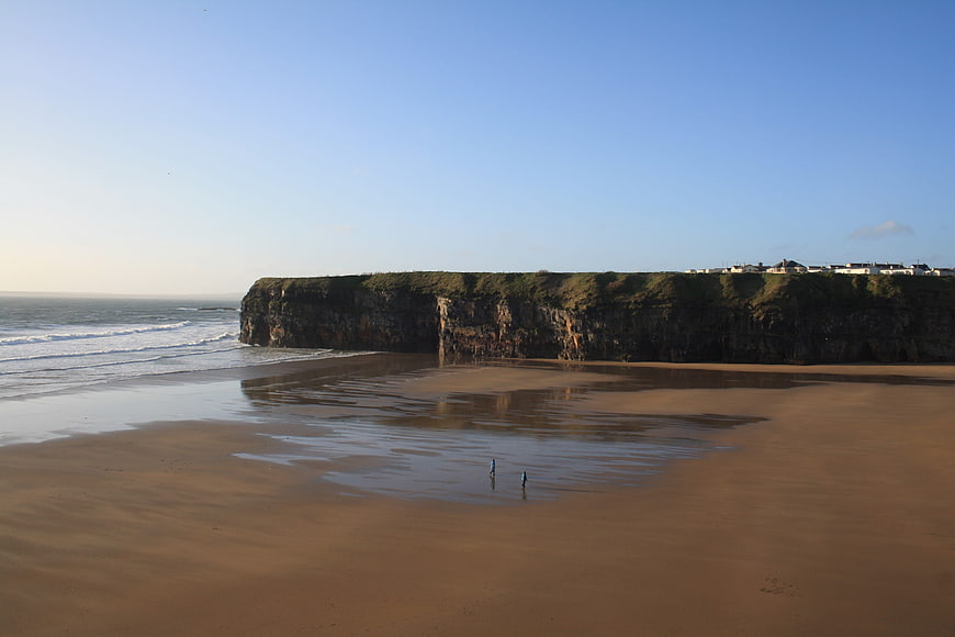 Serene coastal landscape with sandy beach and cliffs