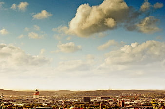 Panoramic Cityscape with Dramatic Clouds and Rolling Hills