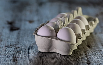 Carton of fresh eggs on rustic wooden table