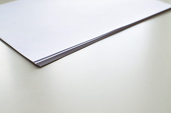 Stack of white paper on a clean desk surface