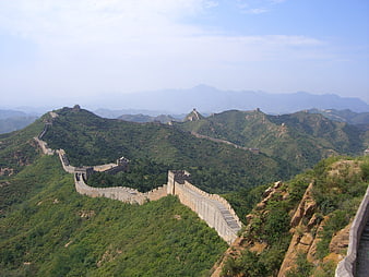 Great Wall of China winding through green mountains