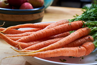 Fresh Raw Carrots with Greens on White Plate