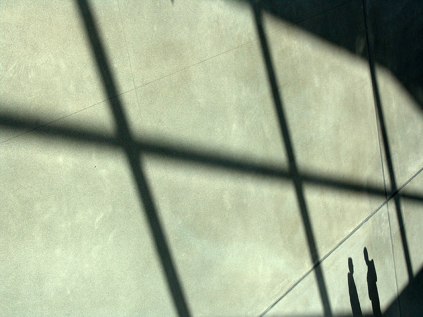 Silhouettes of two people standing in shadows on a wall