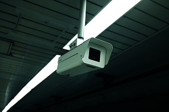 Low angle view of white security camera on ceiling