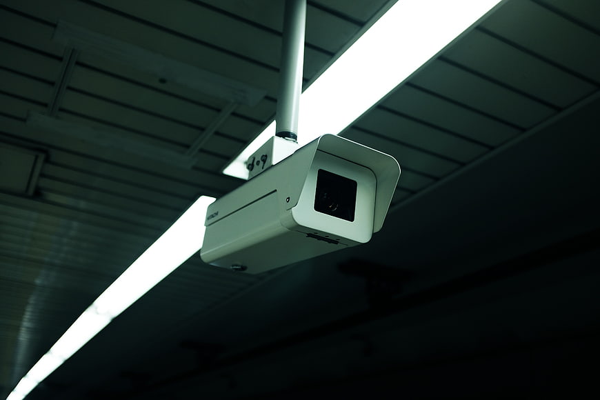 Low angle view of white security camera on ceiling