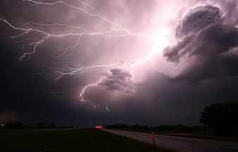 Dramatic Lightning Storm Over Rural Highway at Night