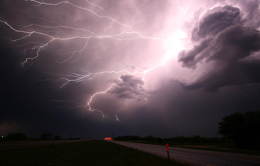 Dramatic Lightning Storm Over Rural Highway at Night