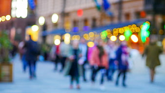 Blurred City Street Scene with Bokeh Lights and Pedestrians