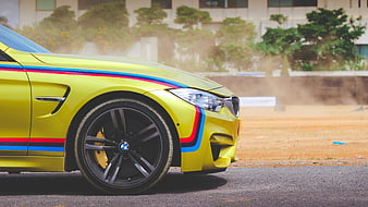 Yellow BMW M4 Sports Car with Racing Stripes