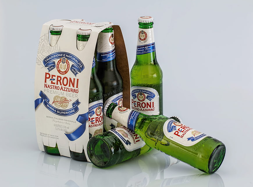 Peroni Nastro Azzurro beer bottles and four-pack on white background