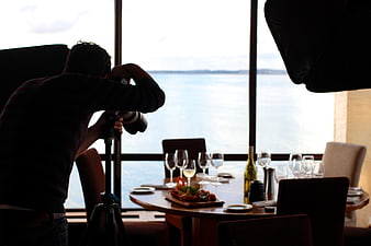 Photographer shooting food on table by window
