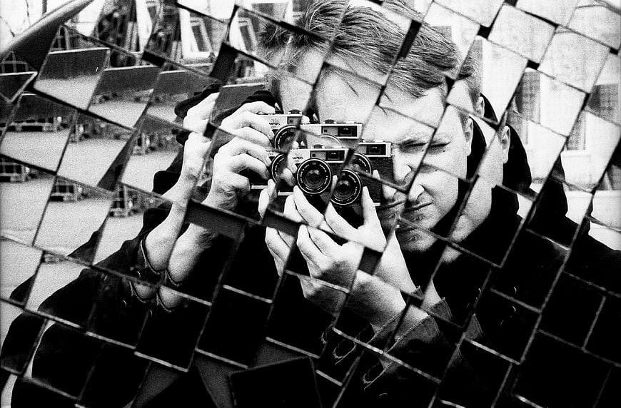 Man taking photo through fragmented mirror reflection