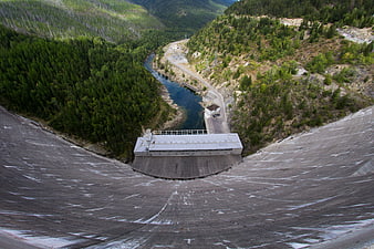Aerial view of massive concrete dam in mountain valley