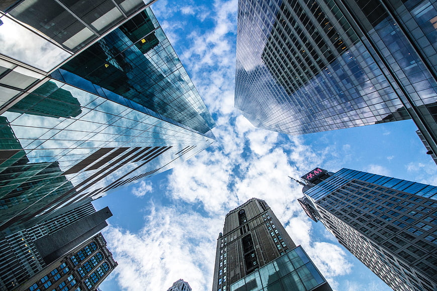 Low angle view of modern skyscrapers against blue sky