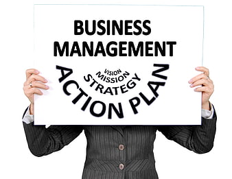 Businesswoman holding business management action plan sign