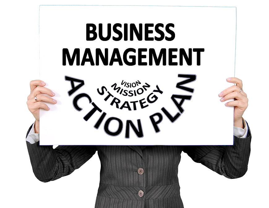 Businesswoman holding business management action plan sign