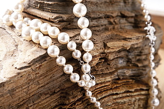 Elegant Pearl Necklace on Textured Driftwood Background