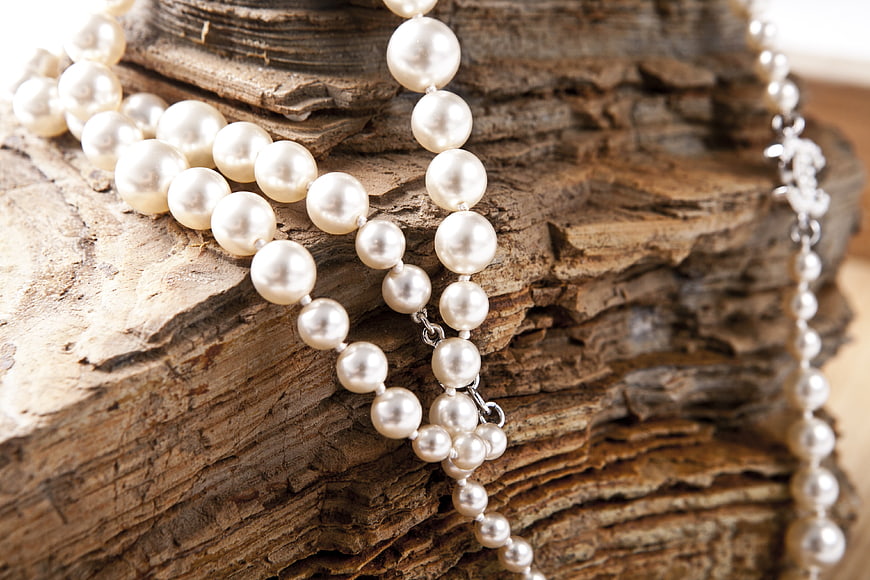 Elegant Pearl Necklace on Textured Driftwood Background