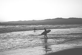 Silhouette of Surfers Walking on Beach in Black and White