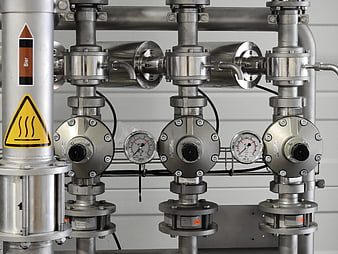 Industrial stainless steel piping system with pressure gauges and valves