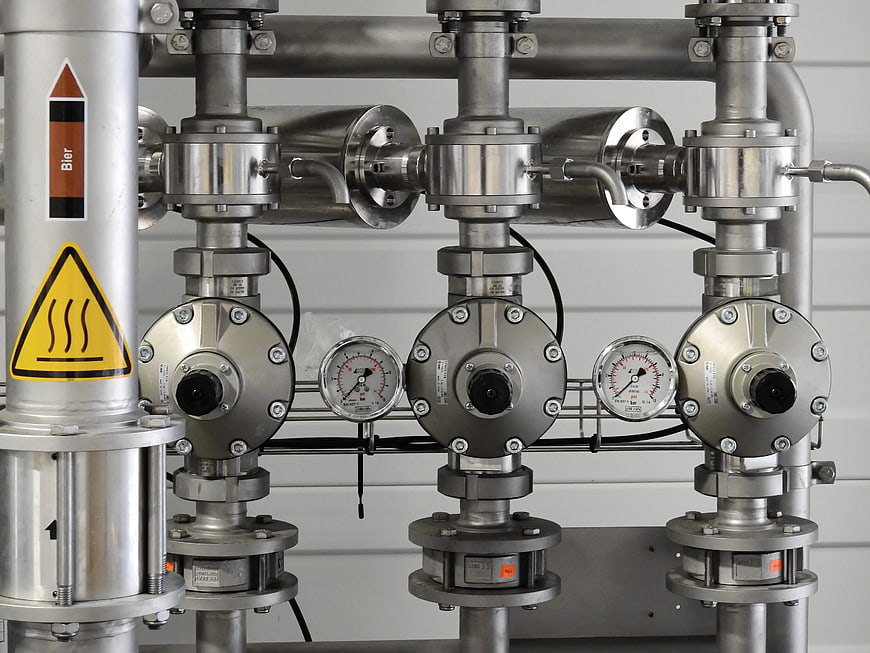 Industrial stainless steel piping system with pressure gauges and valves
