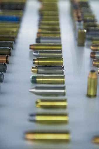 Rows of assorted ammunition cartridges on a white surface