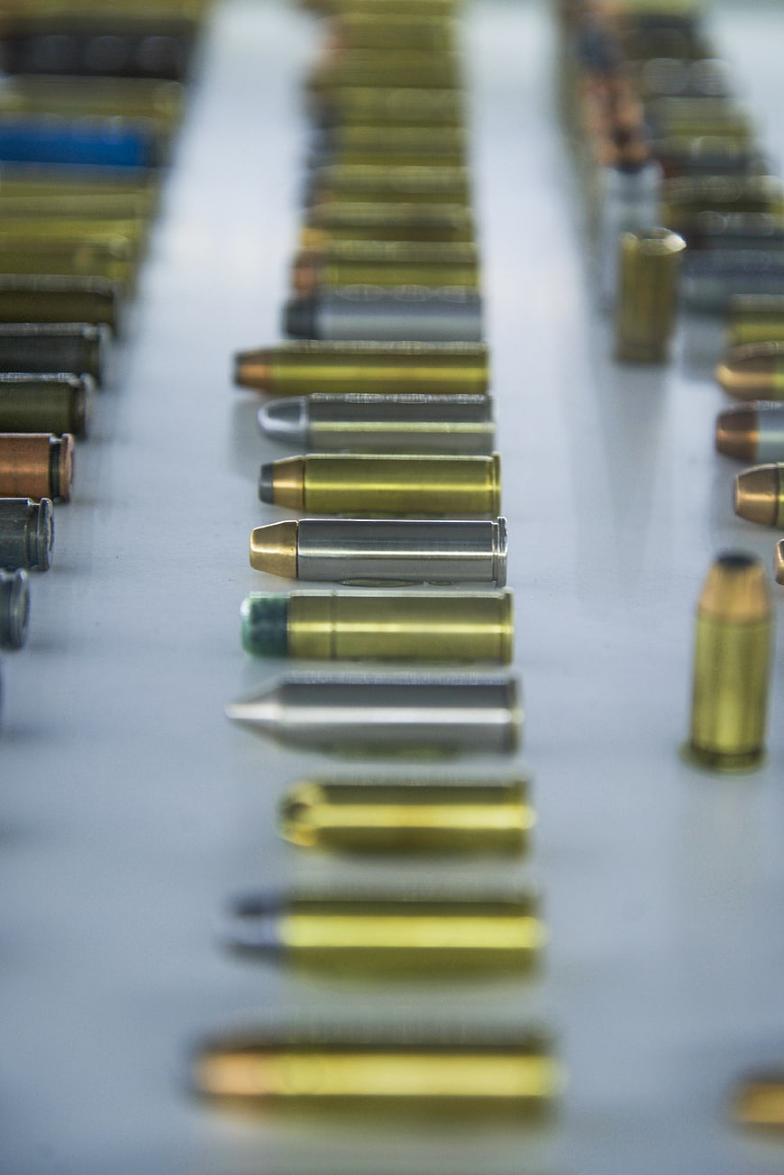 Rows of assorted ammunition cartridges on a white surface