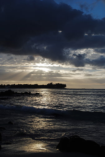 Dramatic Sunset Over Ocean with Sunbeams and Silhouette