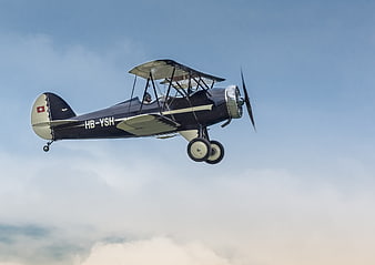 Vintage Swiss Biplane Flying in Blue Sky