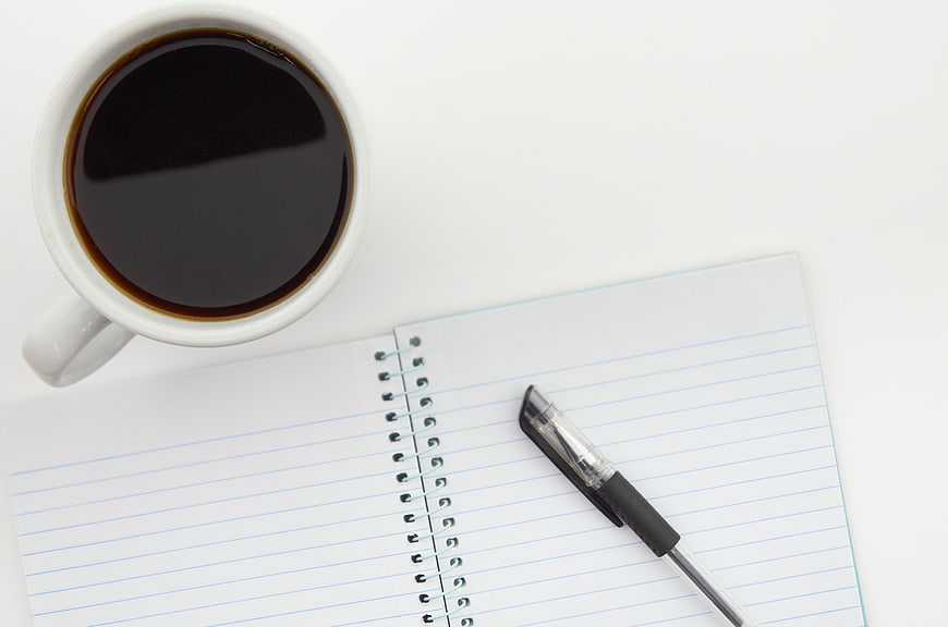 Top View Coffee Cup, Notebook, and Pen on White Desk