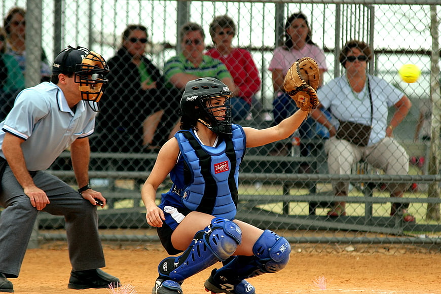 Female Softball Catcher Blocking Ball in Blue Gear