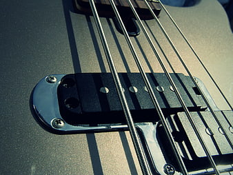 Closeup of black electric guitar bridge and strings
