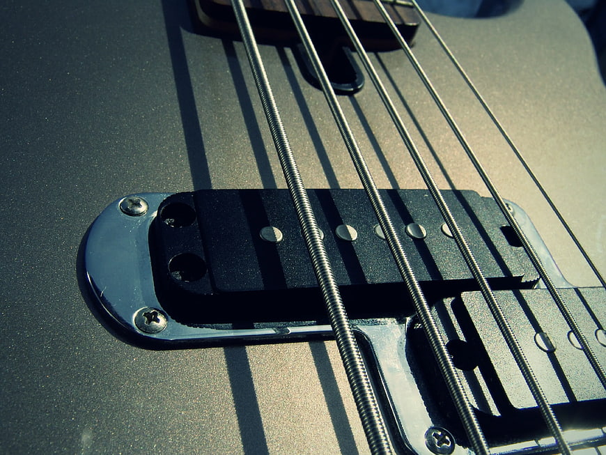Closeup of black electric guitar bridge and strings