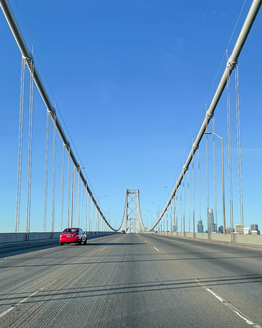Red car driving on San Francisco Bay Bridge