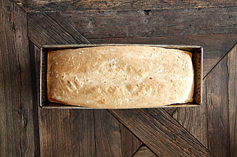 Freshly Baked Loaf of Bread in Pan on Rustic Wood