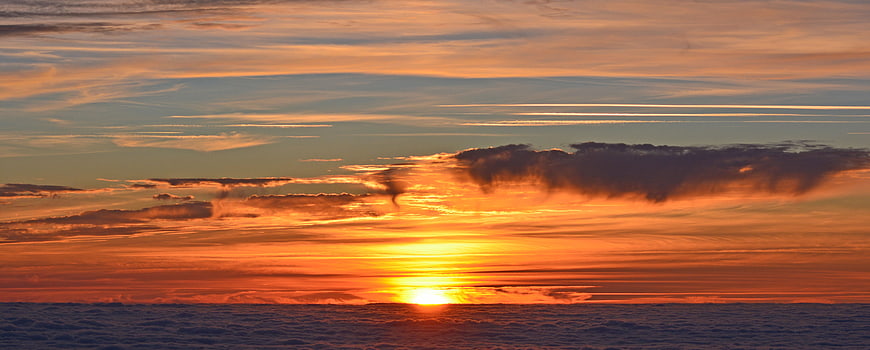Panoramic sunset over ocean with dramatic clouds and golden light