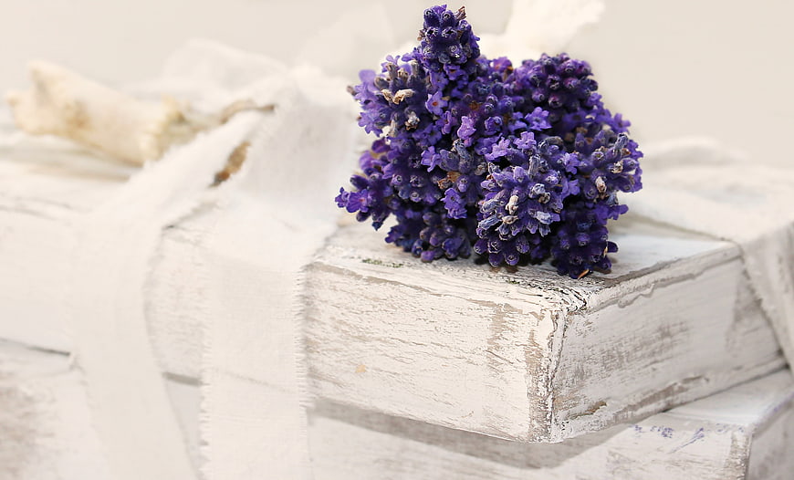 Dried lavender bouquet on stack of white shabby chic books