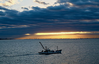 Fishing boat on Tokyo Bay at sunrise with dramatic clouds