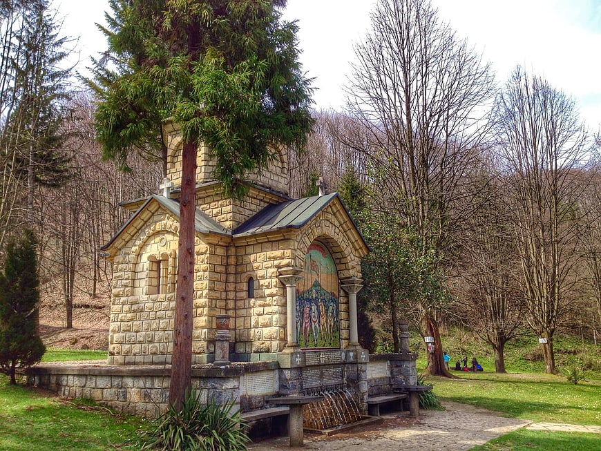 Small Orthodox stone chapel in a forest park with mosaic