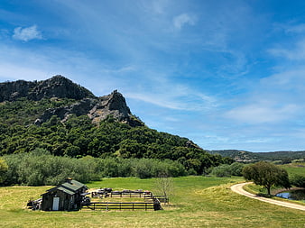 Rustic Barn and Rocky Mountain Landscape in Green Valley