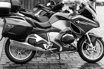 Black and white BMW motorcycle parked on cobblestones
