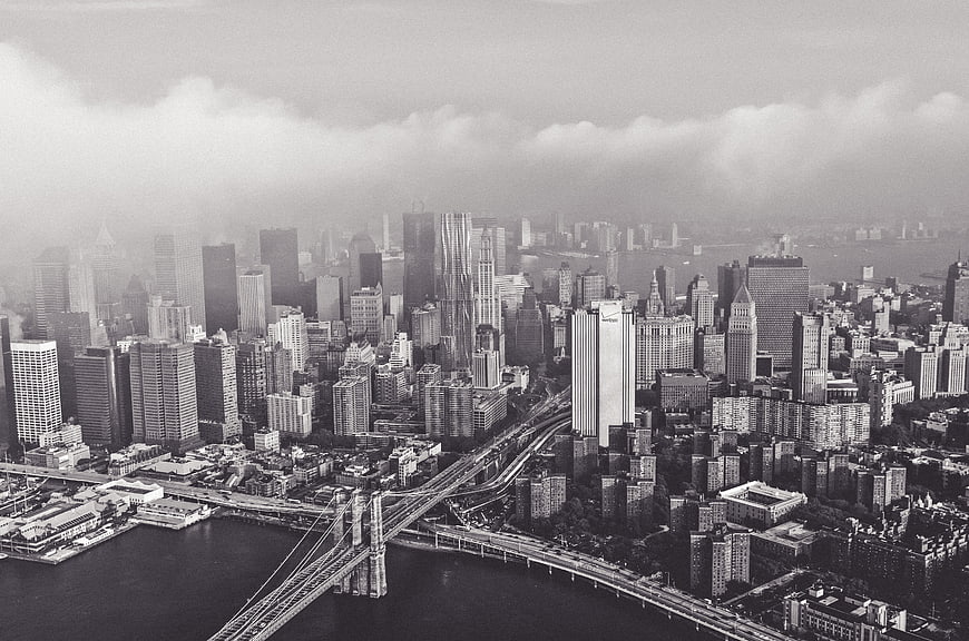 Black and white aerial view of Manhattan skyline and Brooklyn Bridge