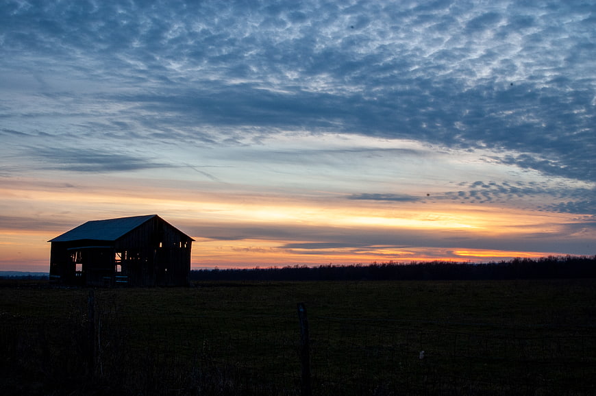 Silhouette of Old Barn Against Dramatic Sunset Sky