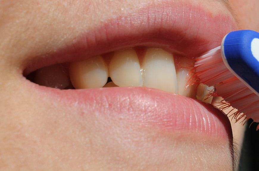 Close-up of person brushing teeth with blue toothbrush