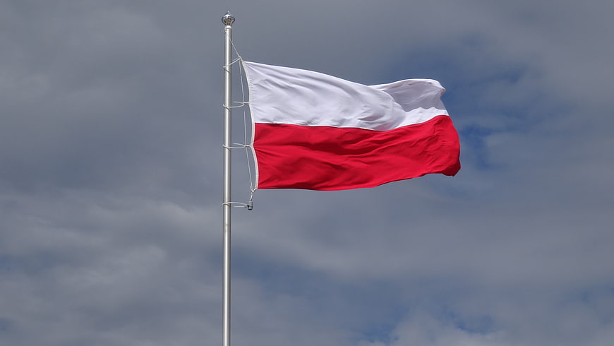 Polish flag waving against cloudy sky