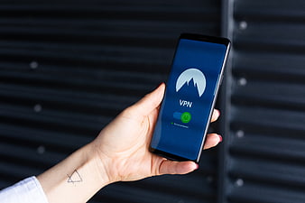 Hand holding smartphone with VPN app interface
